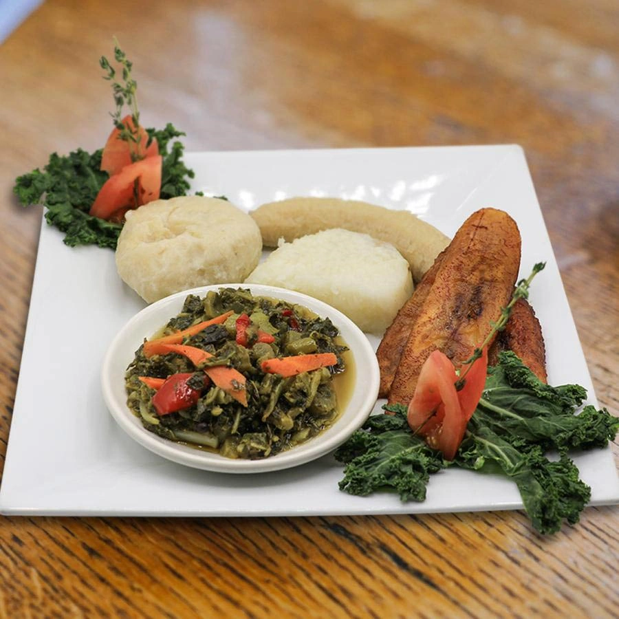 Dish with plantain slices and side of green vegetables and carrot