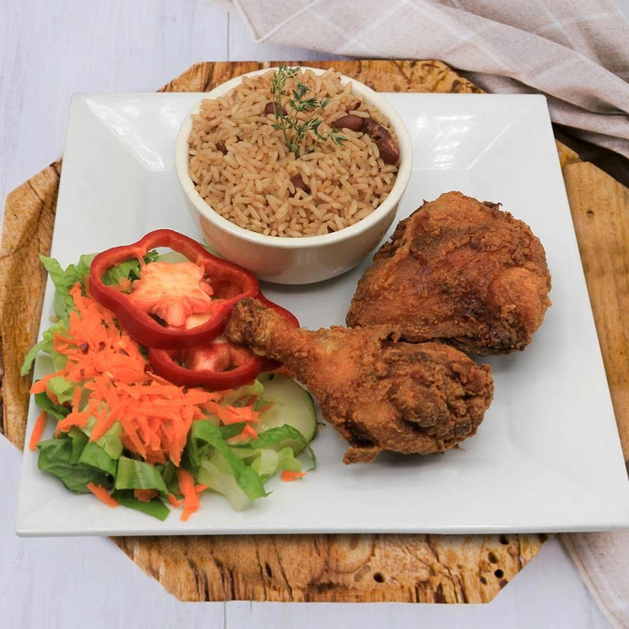 Breaded chicken, rice with beans and side of  salad and peppers