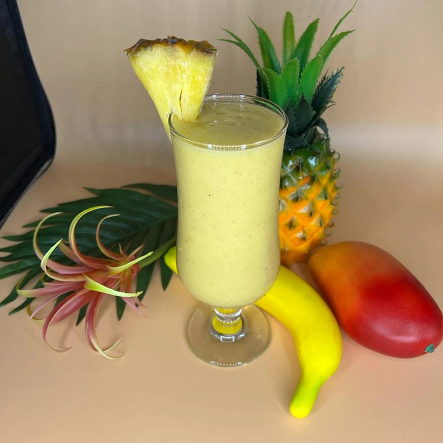 Yellow juice with piece of pineapple and artificial fruits